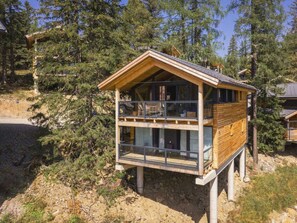A wooden cabin with a balcony and large windows, surrounded by trees. - Superior Chalet # 7 With Sauna & Hot Tub (Stadl-Predlitz)