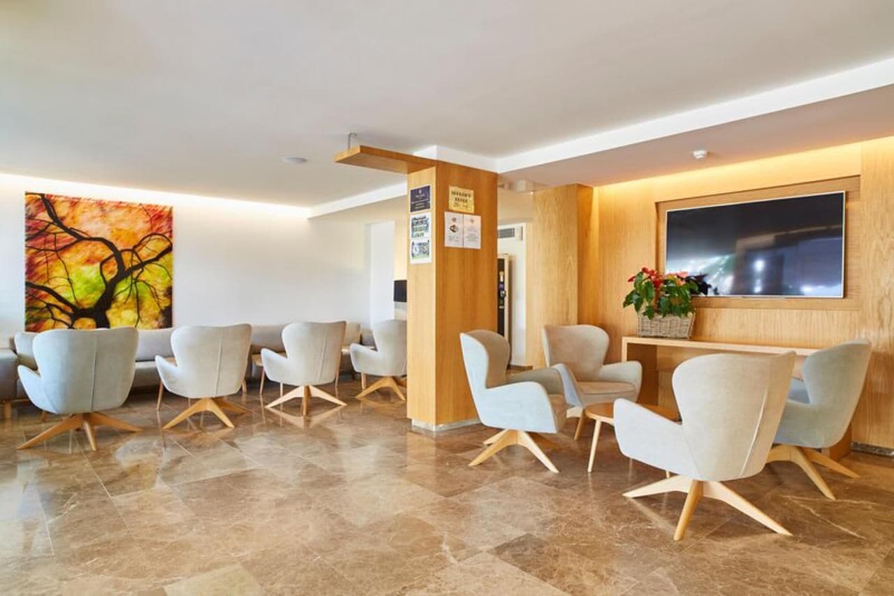 A modern reception area with a large painting, a reception desk, and several seating areas.