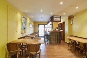 Un interior de restaurante con techos altos, una barra central y varias zonas de estar.
