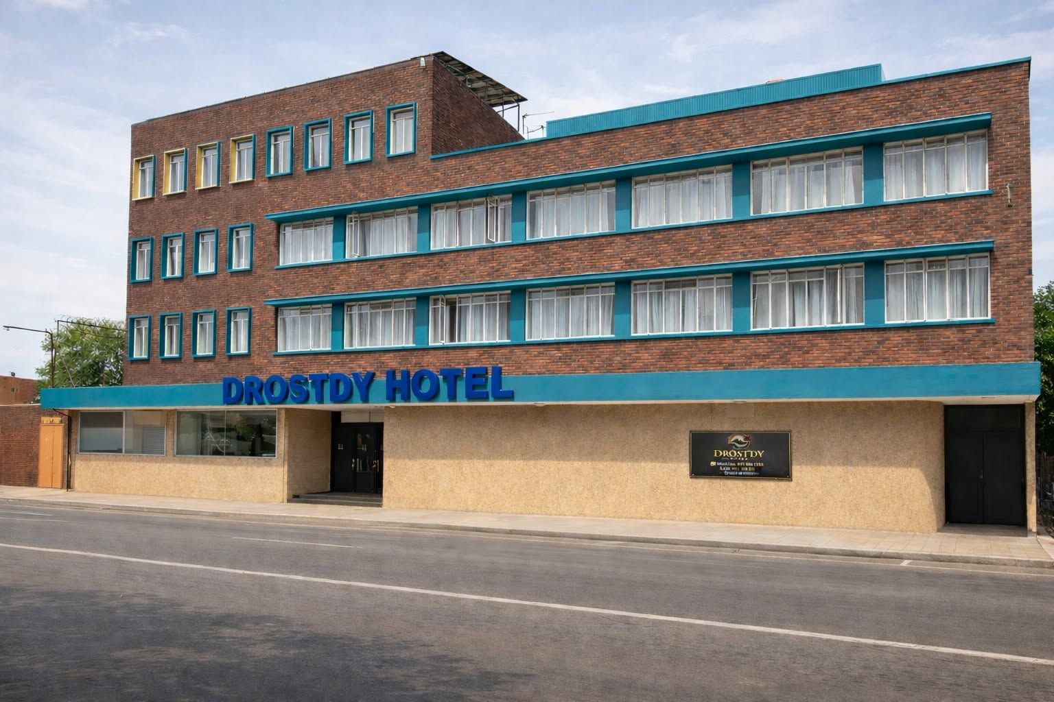 Edificio DROSTDY HOTEL con fachada plana, múltiples ventanas y un cartel.