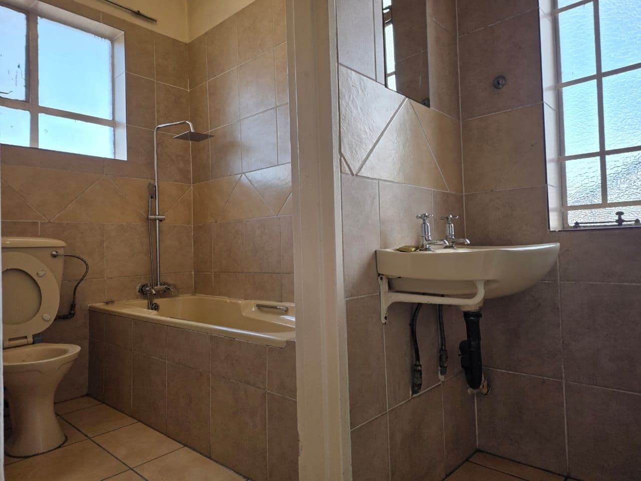 Un baño con bañera, inodoro y lavamanos.