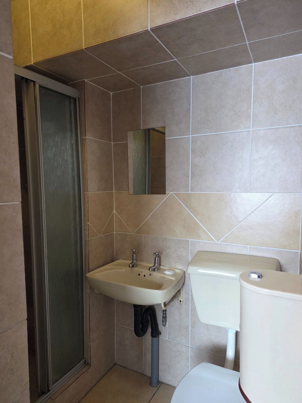 Une salle de bain avec une douche, un lavabo et des toilettes.