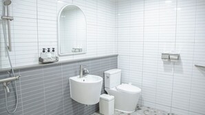 A modern bathroom with a white sink, toilet, and shower. - HOTEL MOMUM (Pohang)