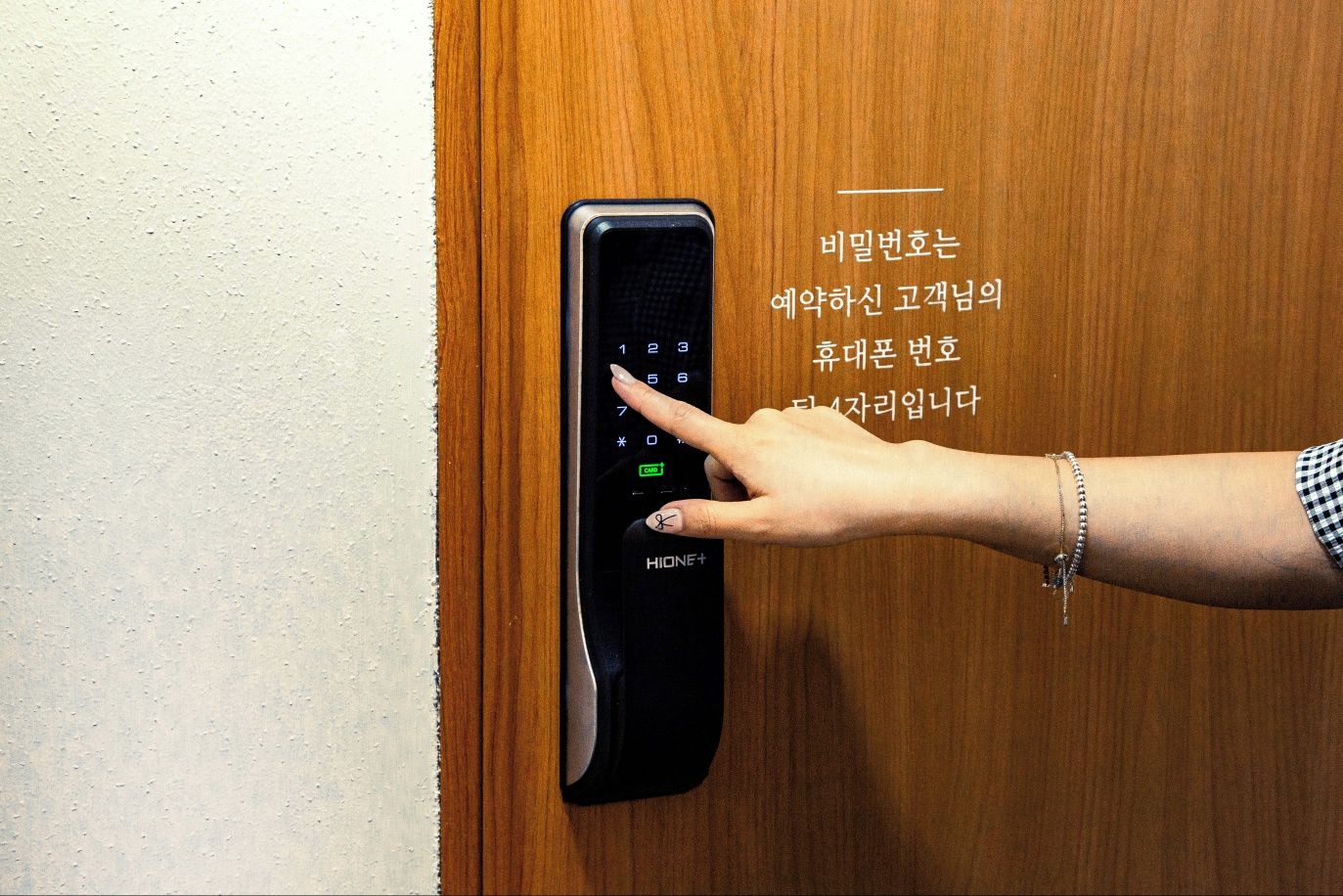 A hand operating a modern electronic door lock with a keypad.