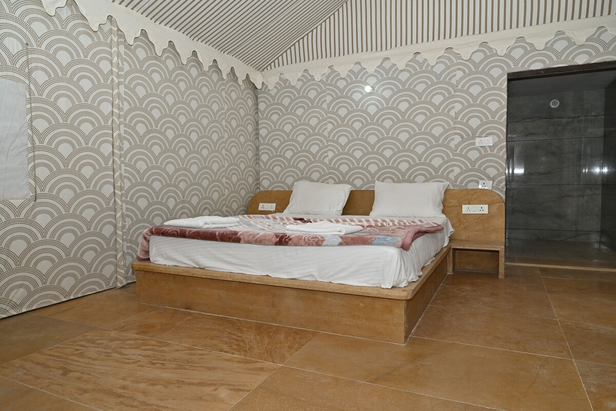 A bedroom with a bed, a nightstand, and a door.
