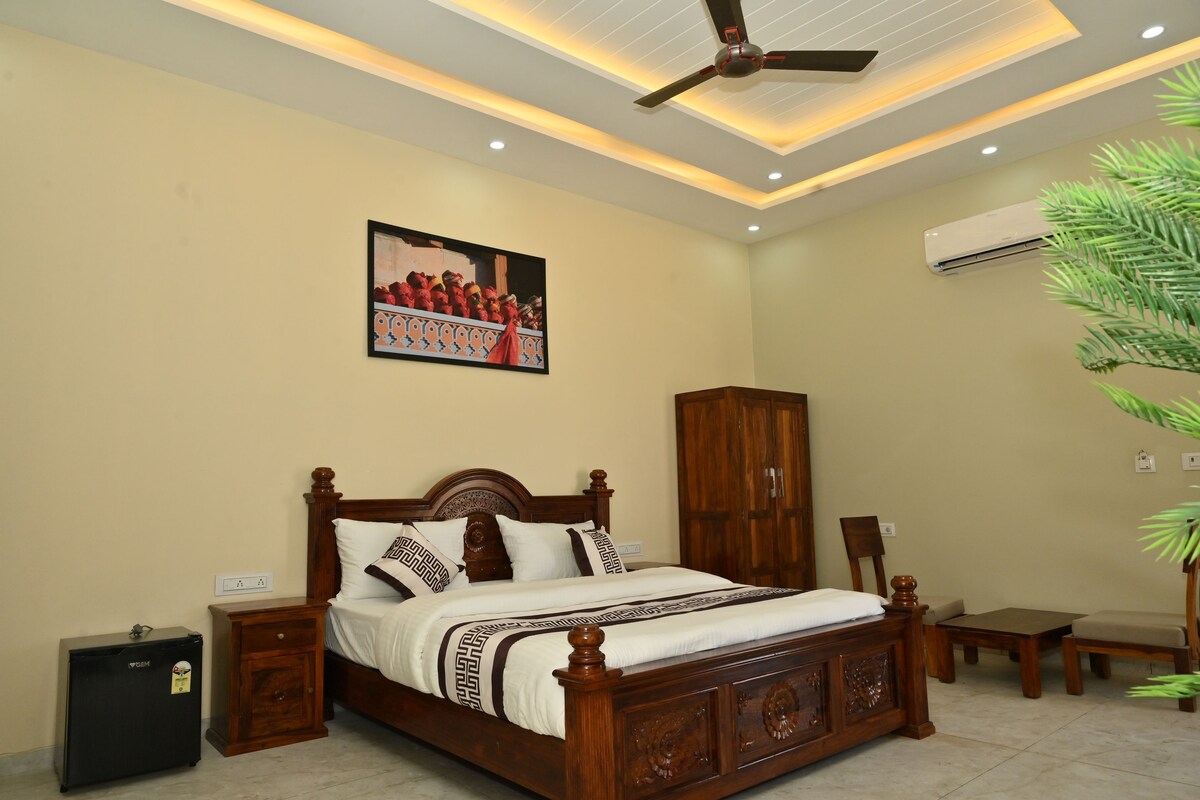 A bedroom with a wooden bed, a nightstand, a wardrobe, a ceiling fan, and an air conditioning unit.