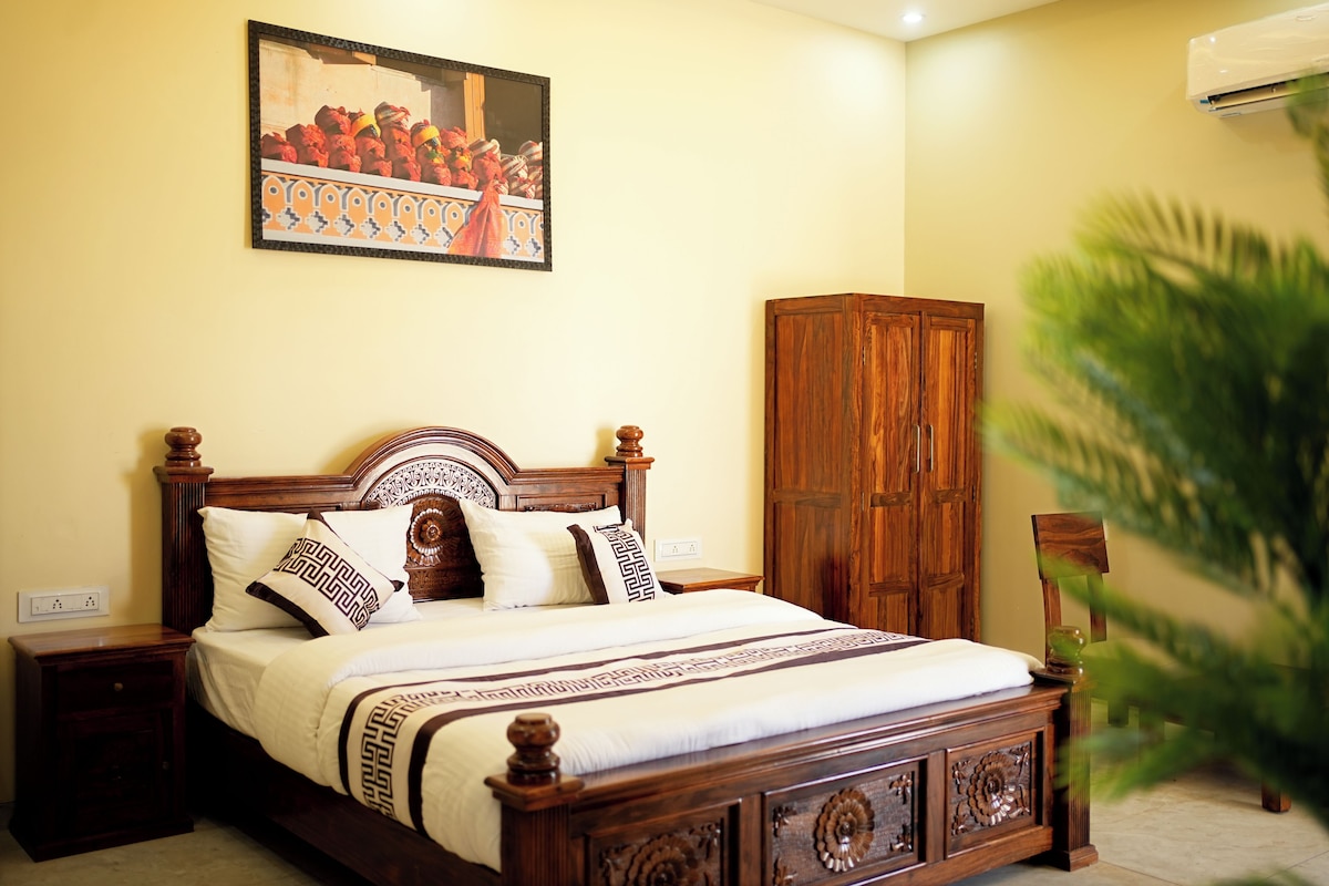 A bedroom with a wooden bed, a nightstand, a wardrobe, and a painting on the wall.