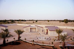 A modern building complex with multiple structures, including a central building with a covered entrance and smaller adjacent buildings. - Sunrise Resorts (Jaisalmer)