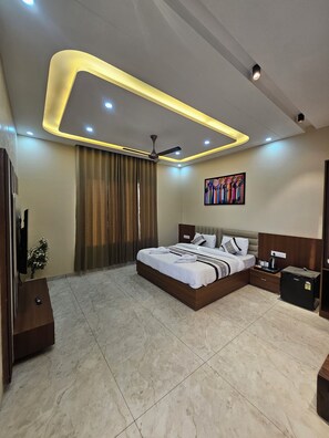 A modern bedroom with a bed, bedside tables, a ceiling fan, and a small refrigerator.