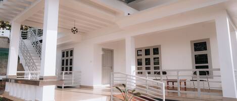 A spacious outdoor area with a white staircase leading to a covered upper level.