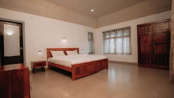 A bedroom with a wooden bed, a nightstand, a wardrobe, and a window with curtains.