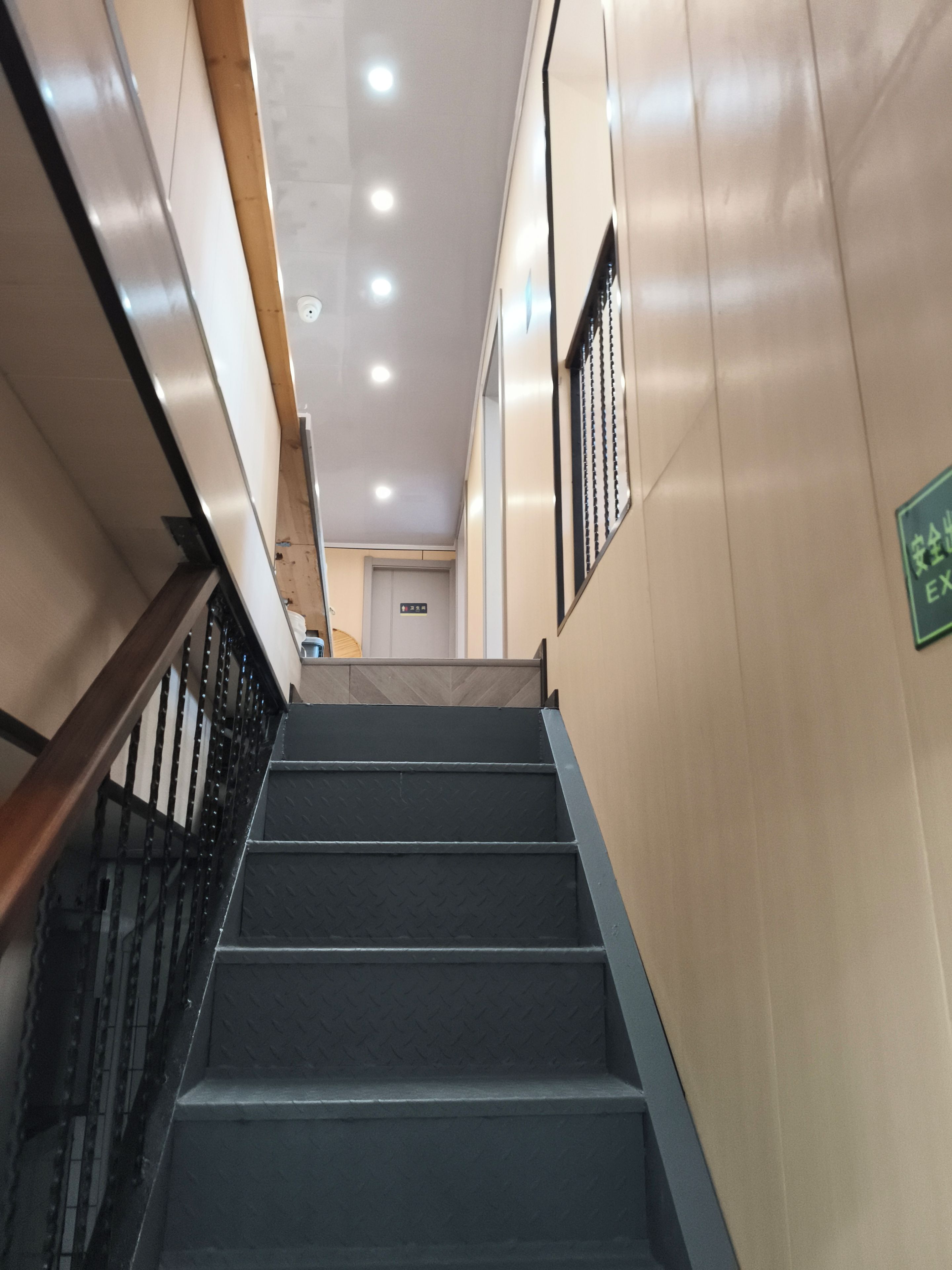 Uma escada com corrimão que leva a um elevador.