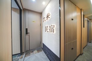 A hallway with a sign indicating room number 801, wooden doors, and a tiled floor. - Jiumihutong Homestay (Qingdao)