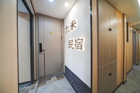 A hallway with a sign indicating room number 801, wooden doors, and a tiled floor.