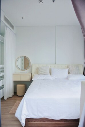 Ein Schlafzimmer mit Bett, Nachttisch, Spiegel und einem Fenster mit Vorhängen.