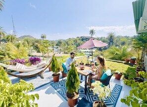 A patio with a table, chairs, and a hammock. - Royal Raj Palace Near Nakki Lake Mount Abu (Aburaj)