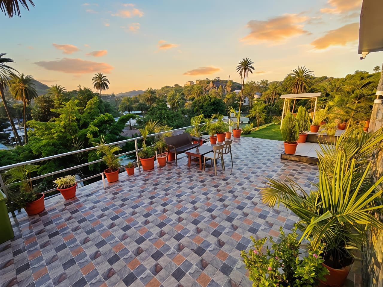 Eine Terrasse mit Schachbrettboden, Gartenmöbeln und Topfpflanzen.