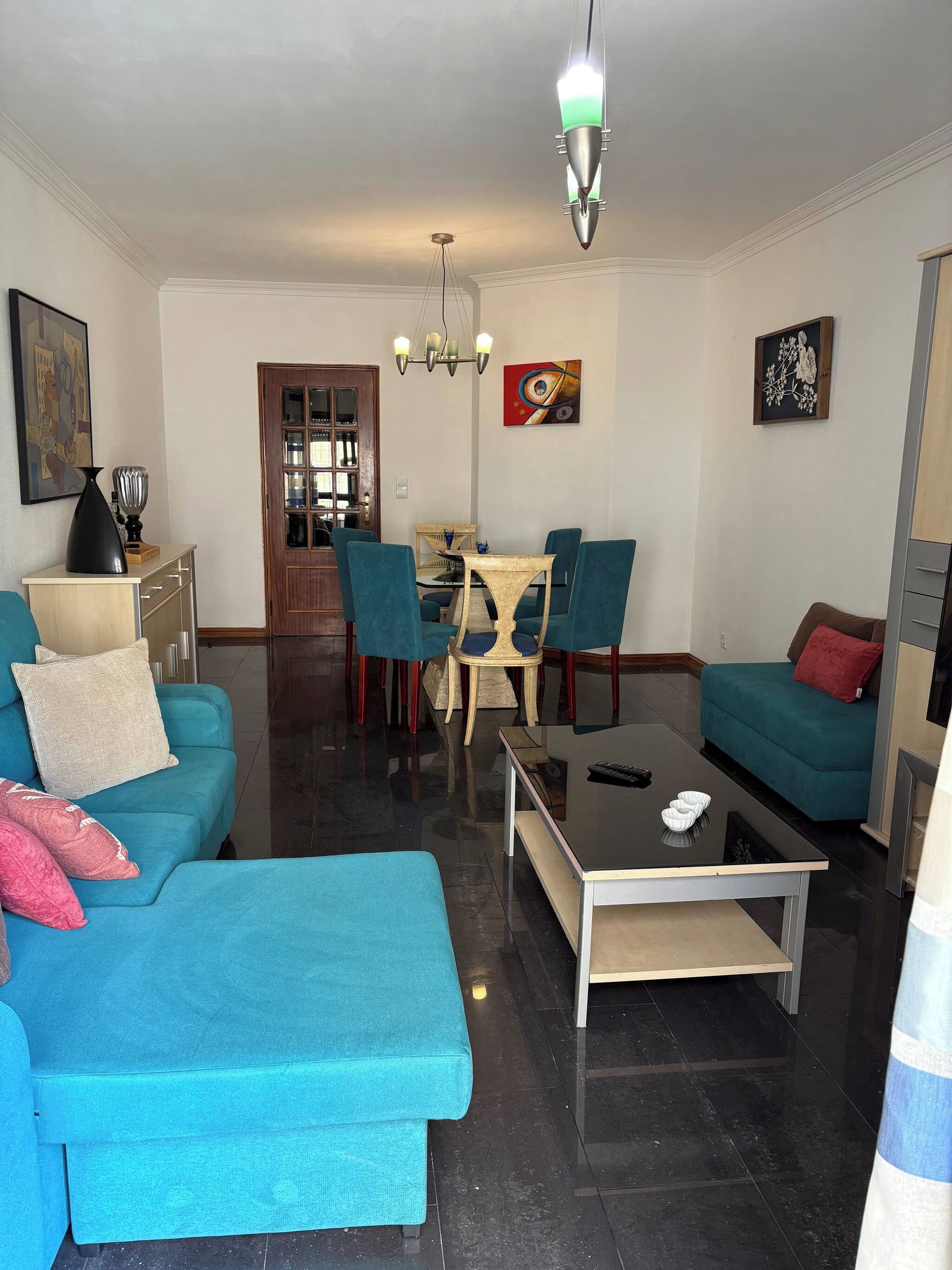 Una sala de estar con un sofá, una mesa de centro y un comedor con sillas y una mesa.