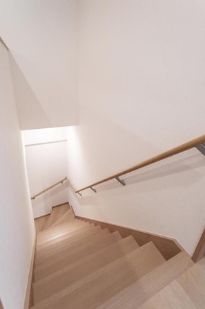 A wooden staircase with a handrail, leading to a landing. - NIKYO Hoshi House Private Villa OSAKA (Osaka)