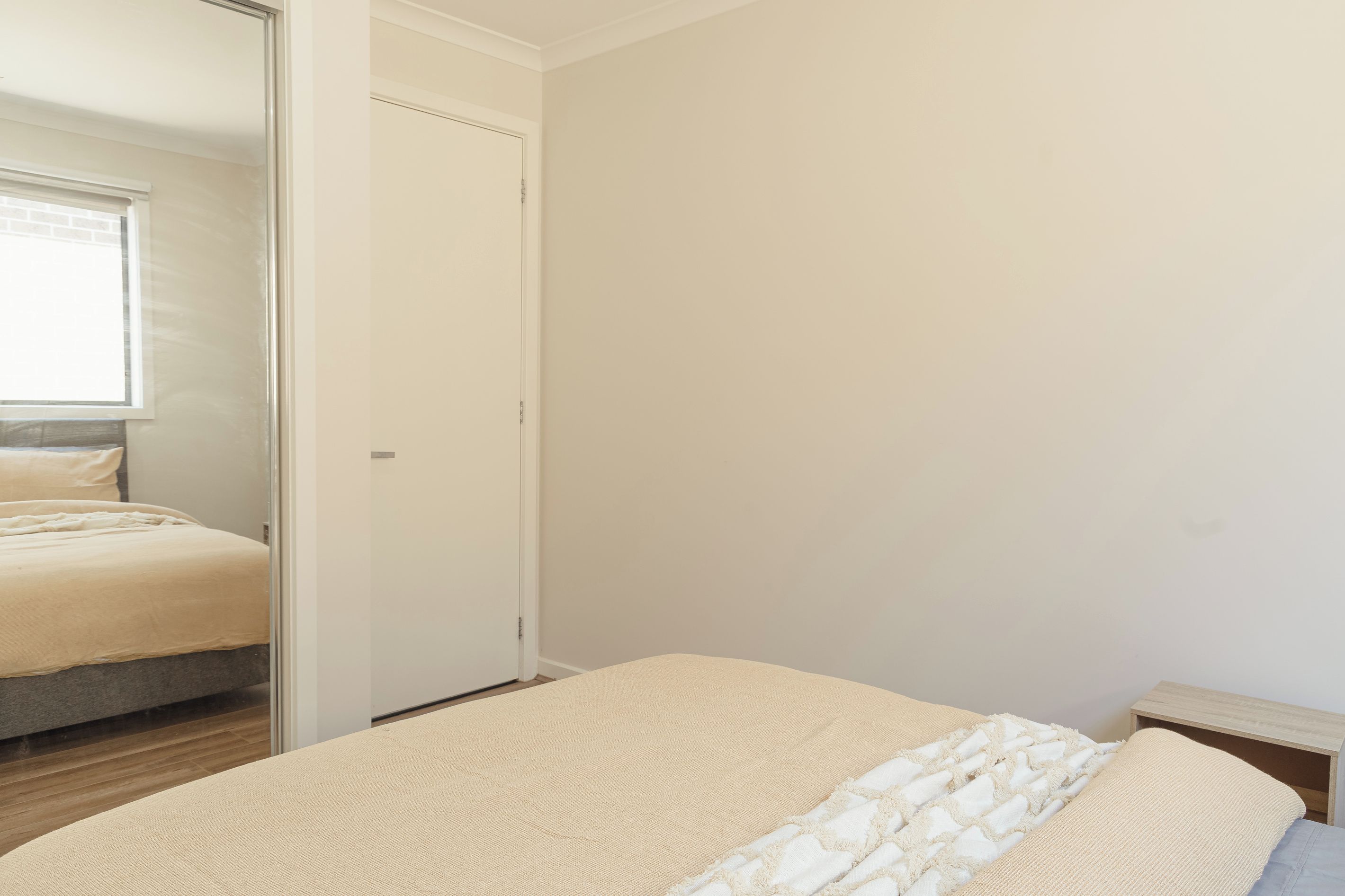 Une chambre à coucher avec un lit, une table de chevet et une porte.