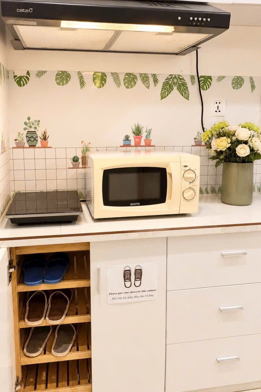Een keuken met een magnetron, een broodrooster en een kast met schoenen.