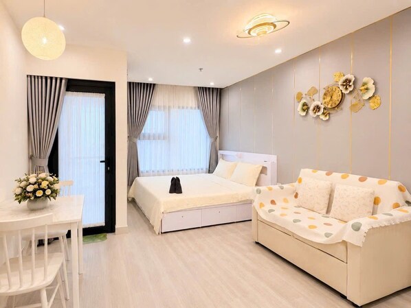 Quarto moderno com cama, sofá e mesa de jantar.