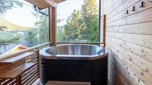 A wooden cabin with a hot tub, wooden deck, and a view of a forest. - Superior Chalet #30 With Sauna & Hot Tub (Stadl-Predlitz)