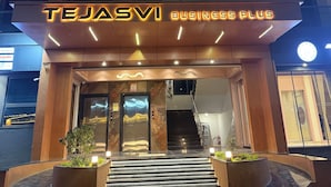 A modern building with a prominent illuminated sign reading 'TEJASVI BUSINESS PLUS'. - Hotel Tejasvi Inn (Junagadh)