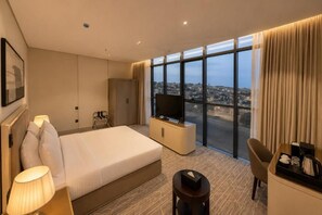 A hotel room with a bed, a television, a desk, and a chair. - NILVA HOTEL فندق نيلفا (Abha)