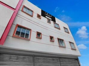 A building with a flat facade, multiple windows with red frames, and a clear blue sky in the background. - Classic Joka Industrial Plaza (Alipur)