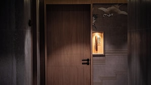 A wooden door with a traditional design, a keyhole, and a small illuminated panel with text. - THE HAN HOTEL (Kathmandu)