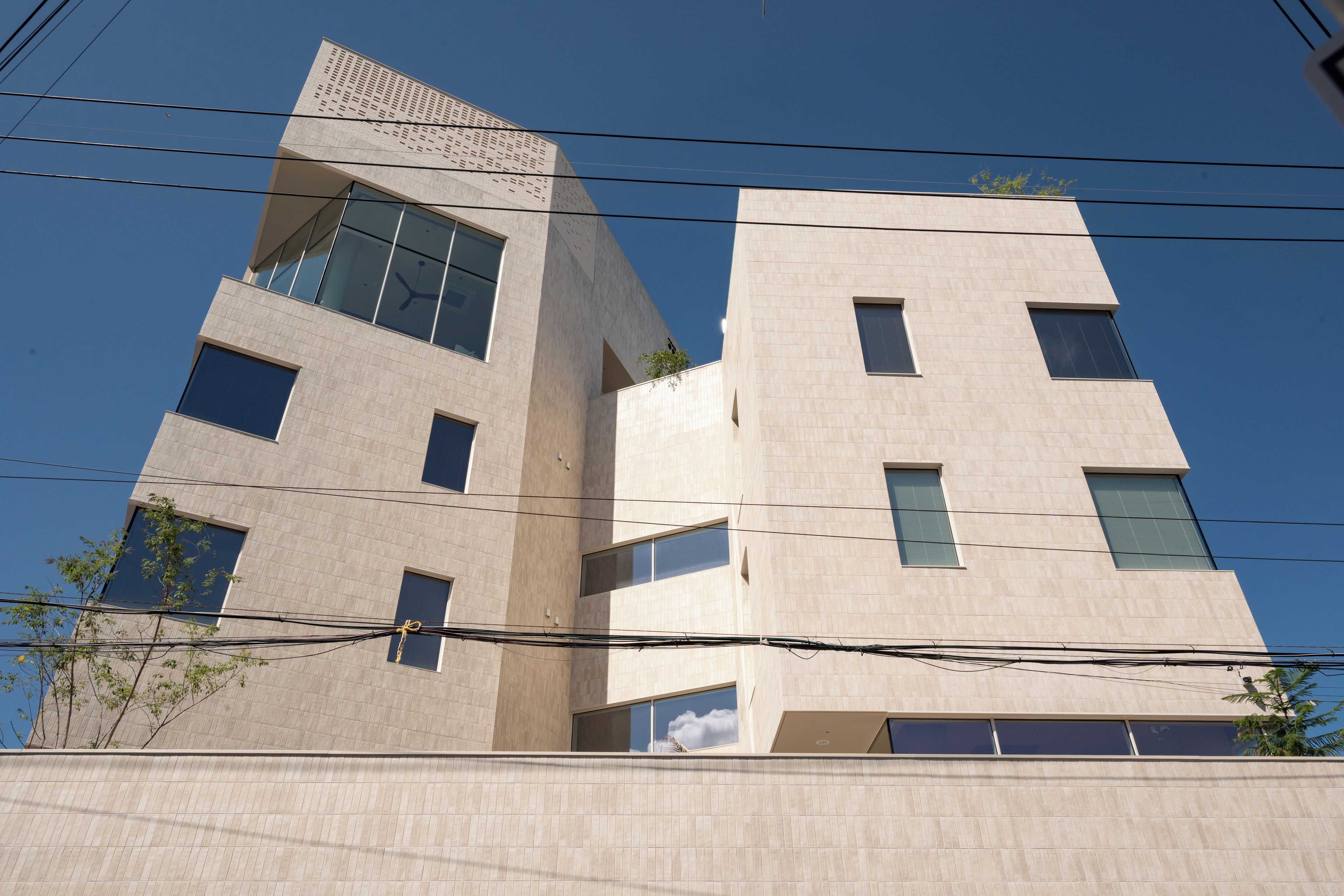 A multi-story building with a modern architectural design, featuring large windows and a flat facade.