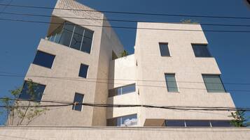 A multi-story building with a modern architectural design, featuring large windows and a flat facade.