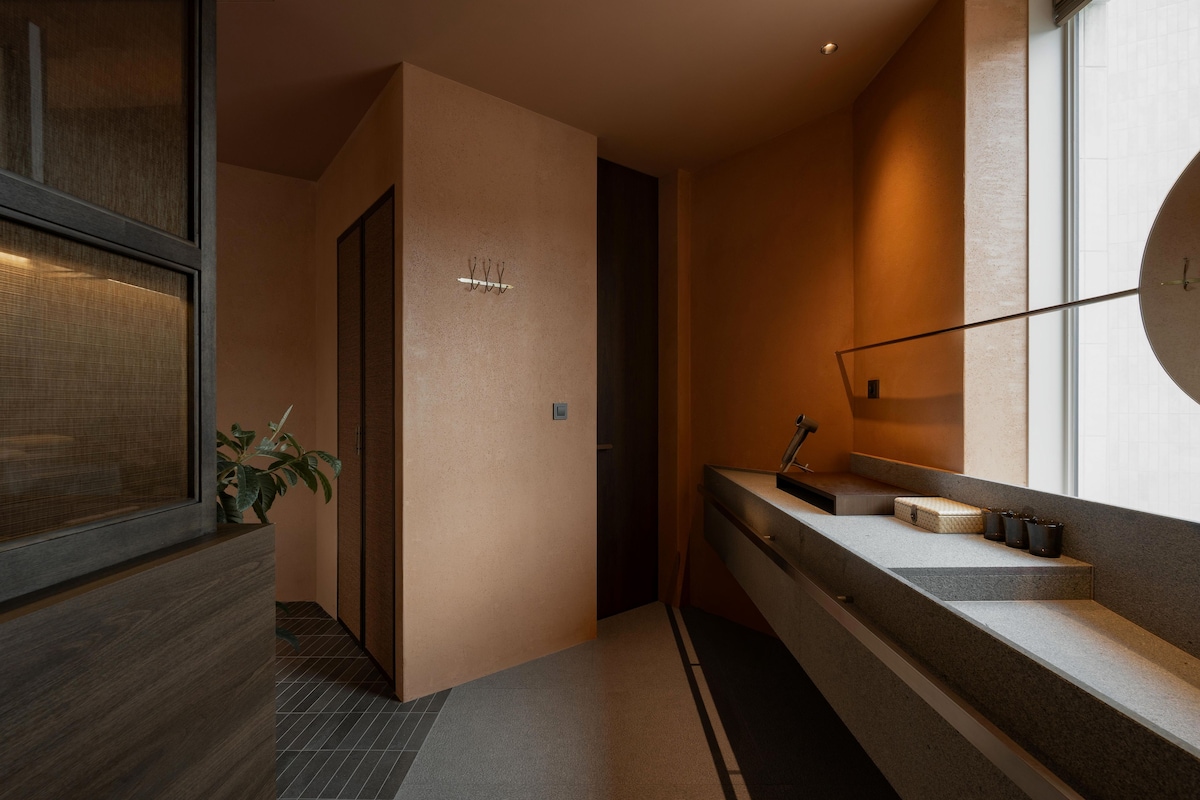 Un baño moderno con tocador de madera, un espejo y una planta.