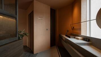 A modern bathroom with a wooden vanity, a mirror, and a plant.