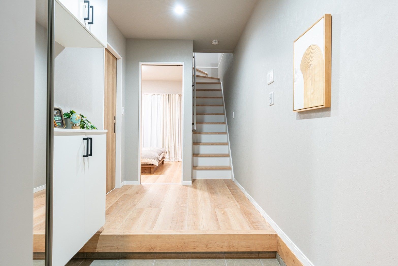 A modern interior with a wooden staircase leading to a bedroom.