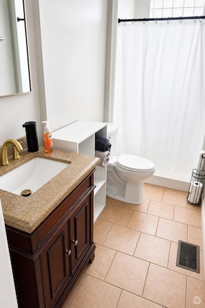 Een badkamer met een wastafel, toilet en douchegordijn.