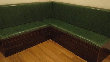 A corner sofa with a dark wood base and green upholstery.