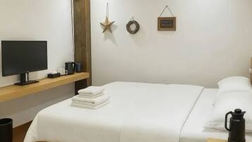 A hotel room with a bed, a TV, a coffee maker, and a shelf with a star decoration and a sign.
