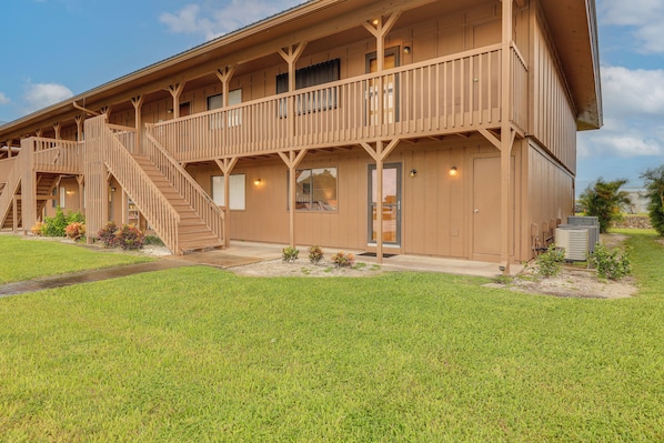 A two-story wooden building with a balcony, a staircase, and a door.
