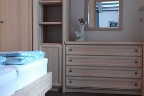 Un dormitorio con una cama, un aparador y un espejo.