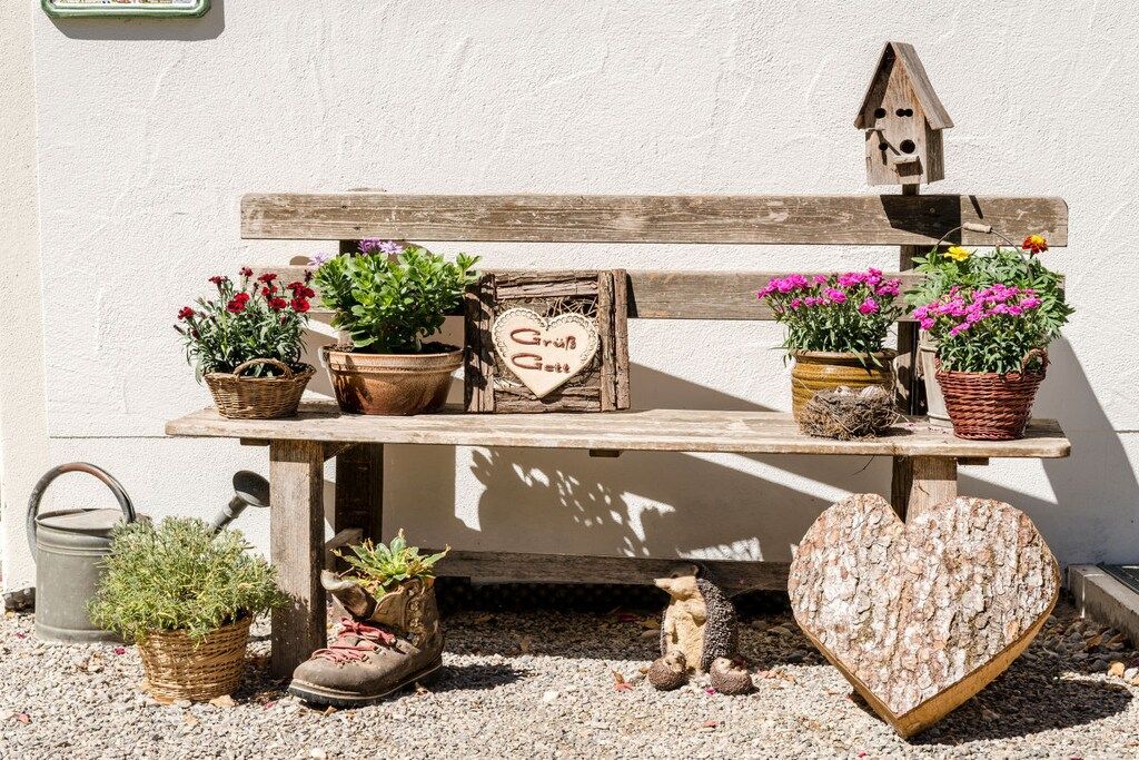 Una panca di legno con piante in vaso e una decorazione a forma di cuore.