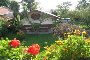 A building with a sloped roof and a wooden bench in front. - 2 "Beim Paulfischer" directly on Lake Chiemsee (Chieming)