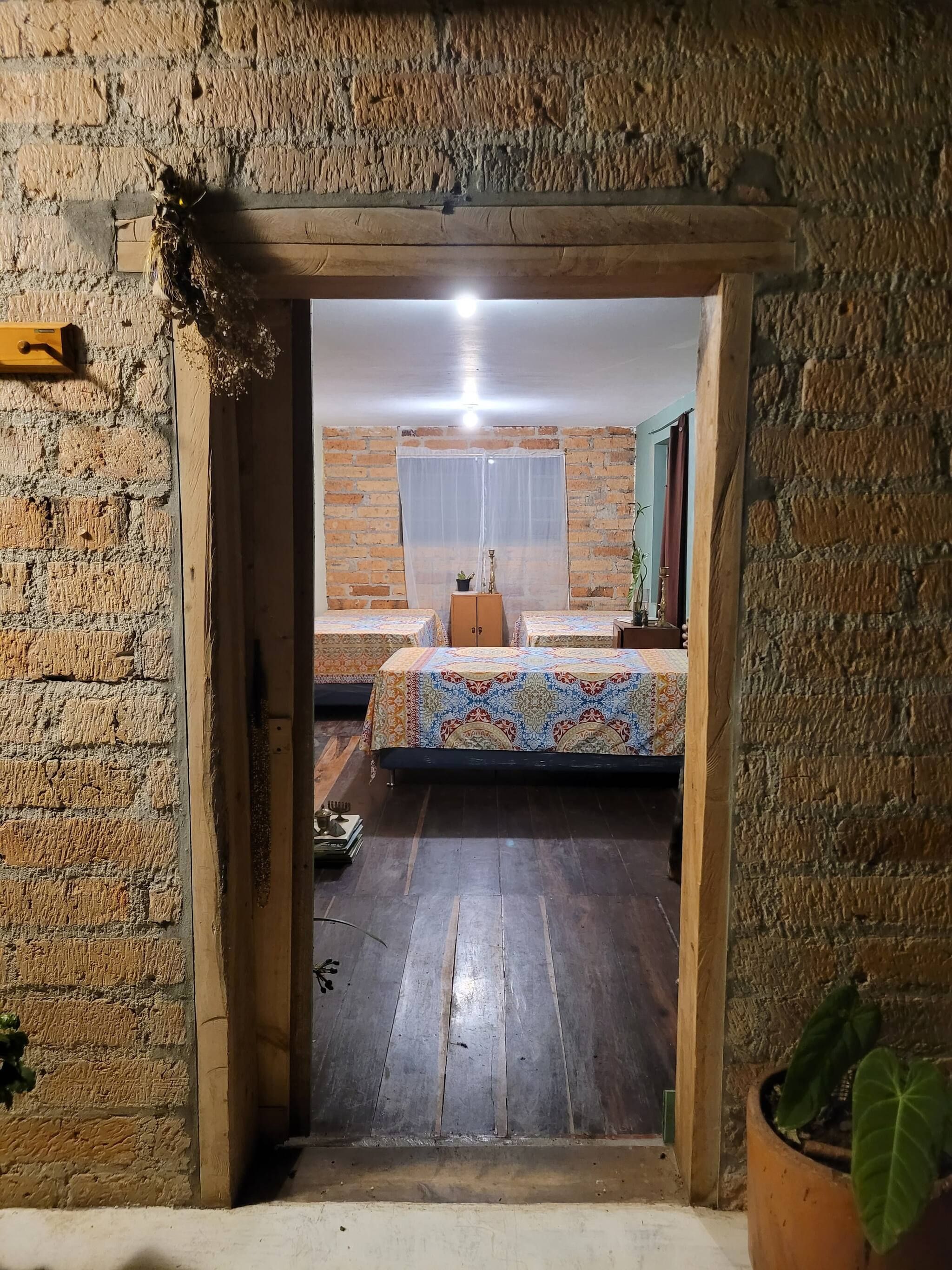 Ein Zimmer mit einem Bett, einem kleinen Tisch und einer Topfpflanze.
