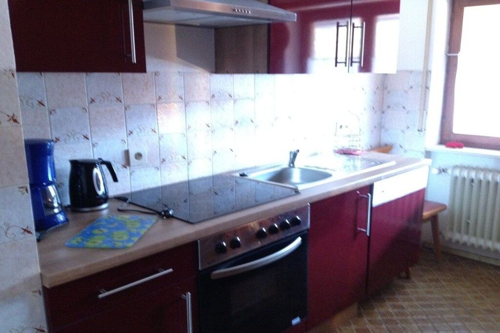 A kitchen with a stove, oven, sink, and cabinets.