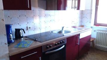 A kitchen with a stove, oven, sink, and cabinets.