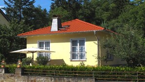 A yellow building with a red roof, white windows, and a stone wall in front. - Holiday home in Remagen with swimming pool (Remagen)