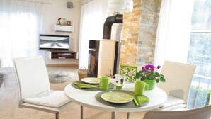 A dining area with a round table, chairs, and a view of the outdoors. - Holiday home in Remagen with swimming pool (Remagen)