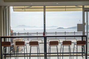 A view from a balcony with a railing, overlooking a body of water and distant land. - Incheon Ganghwa 917 Motel (Incheon)