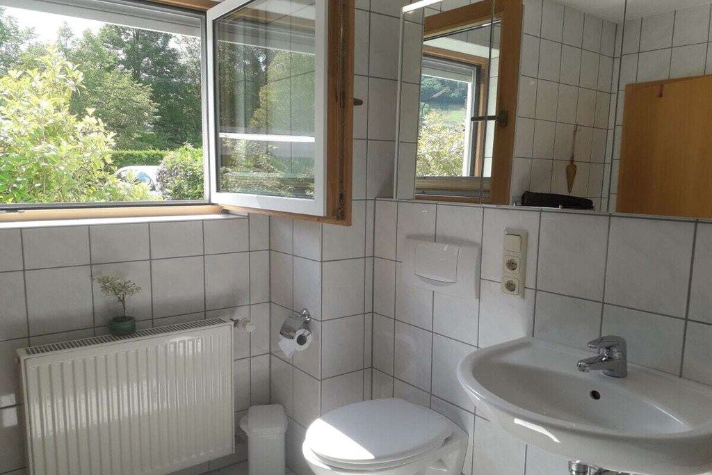 Un baño con inodoro, lavabo y ventana.